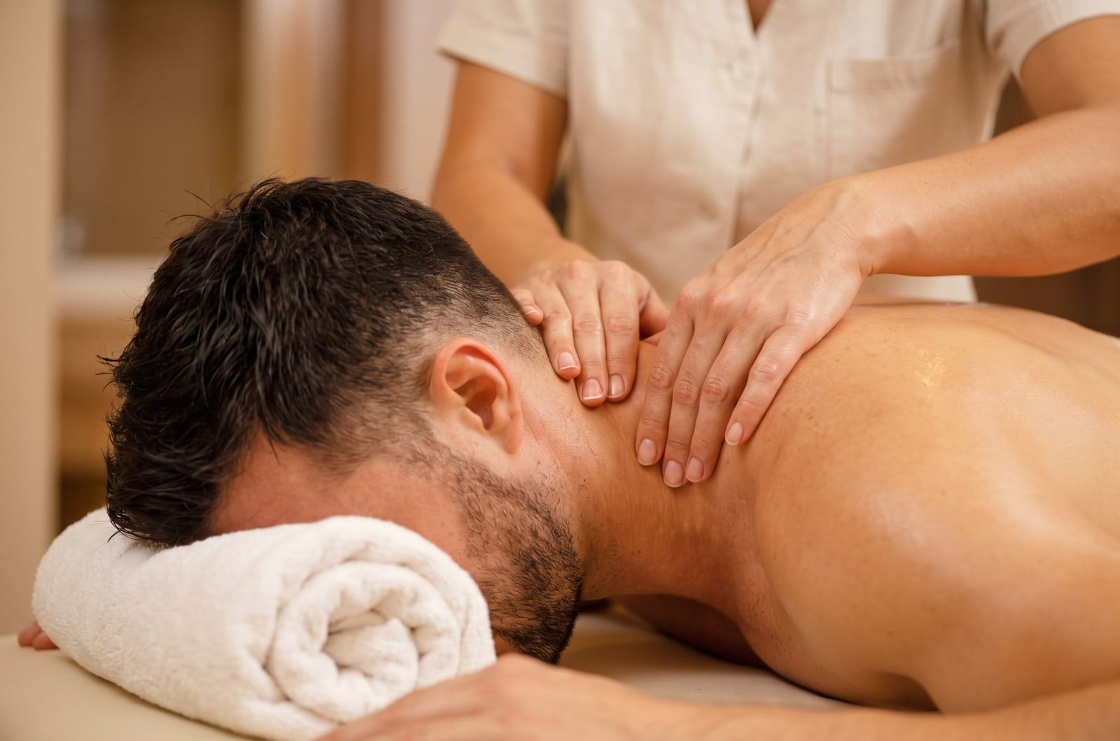 A therapist massaging a client's neck and shoulders